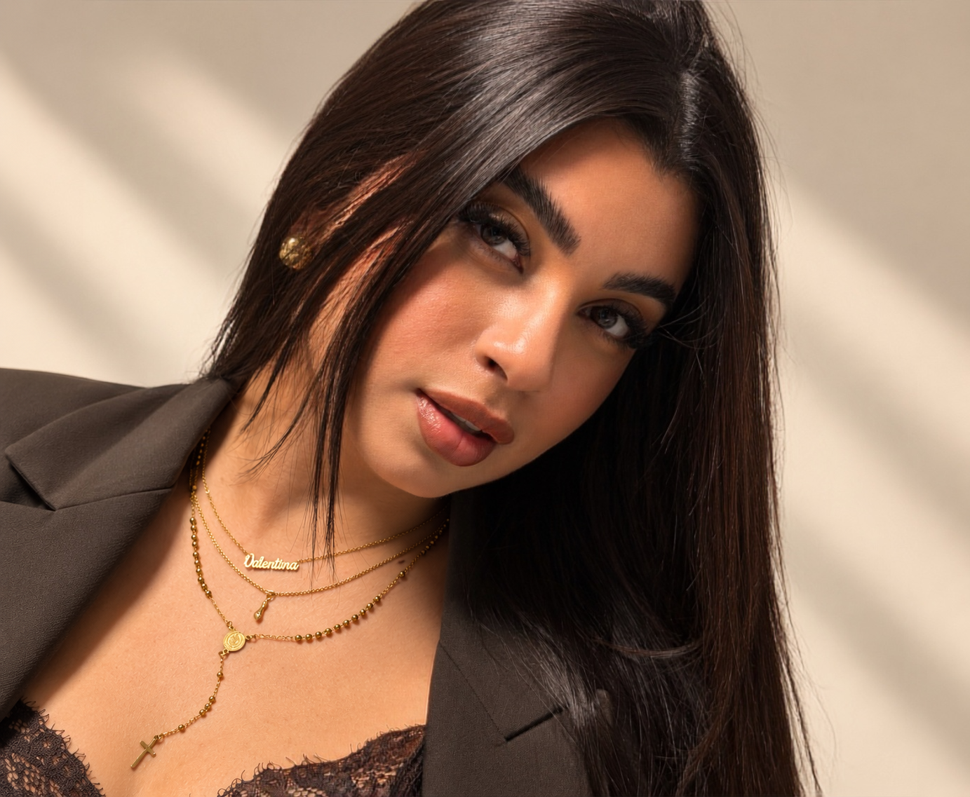 Modelo con pendientes, anillos y collares dorados de Be You Brand